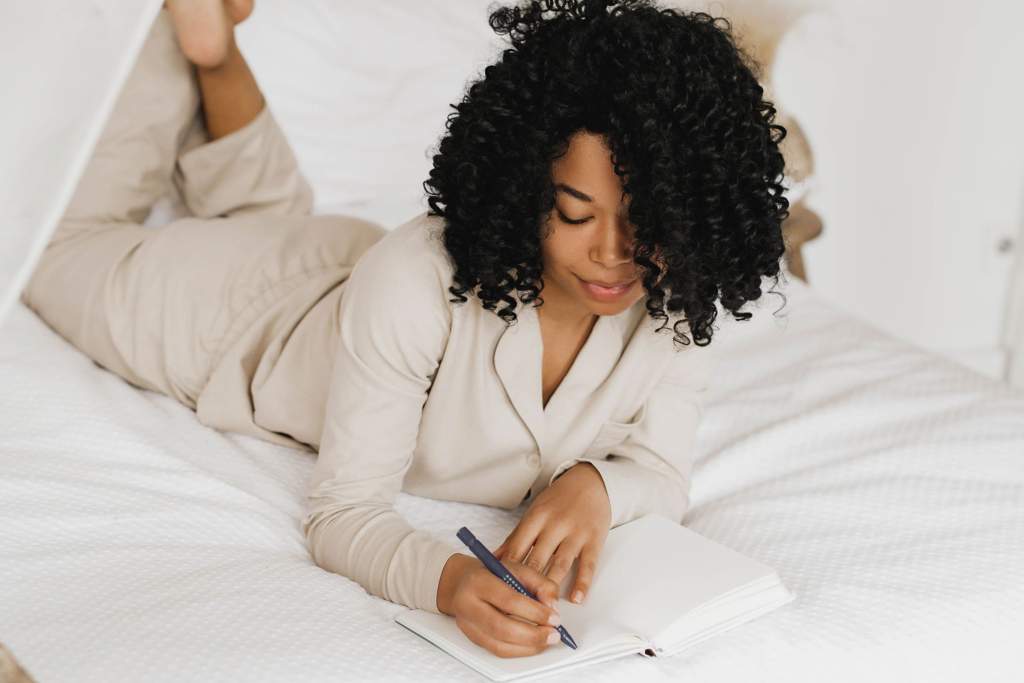 A person using a planner and ticking off tasks for their monthly reset routine, demonstrating organization and control in their life