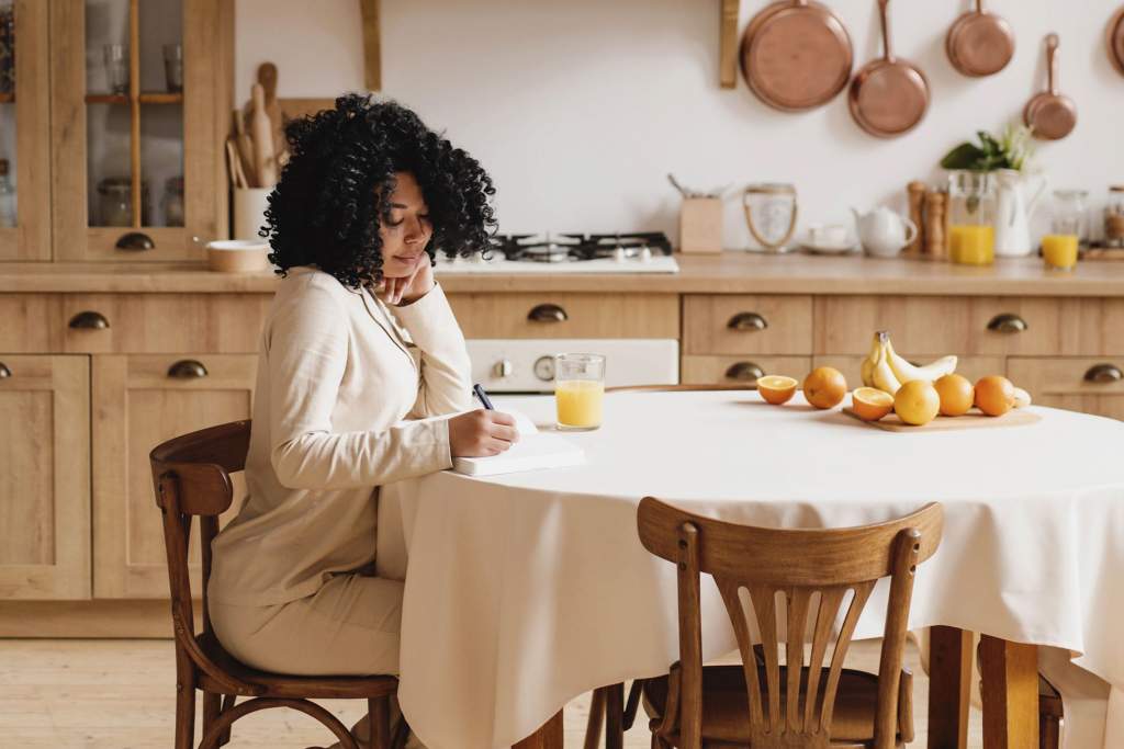 A person using a planner and ticking off tasks for their monthly reset routine, demonstrating organization and control in their life