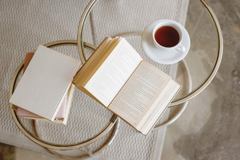 Read books as apart of your goals for November. This is an image showing a cozy book with a warm cup of coffee