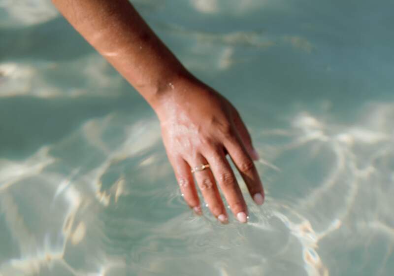  hand with a ring submerged in water, symbolizing peace