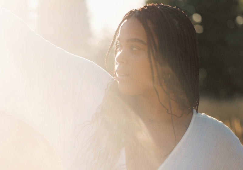 A woman in a white dress standing in a field, a featured image about manifesting affirmations