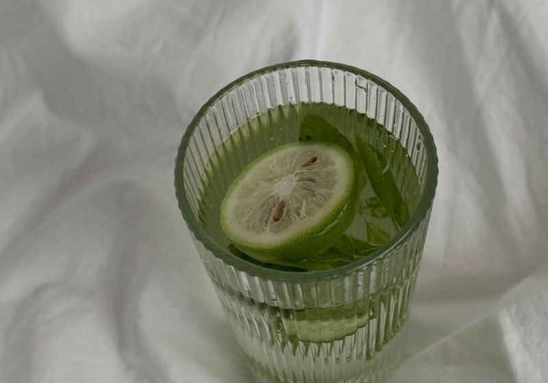  A vibrant glass of green drink topped with a lime slice, representing the essence of high vibrations and wellness.