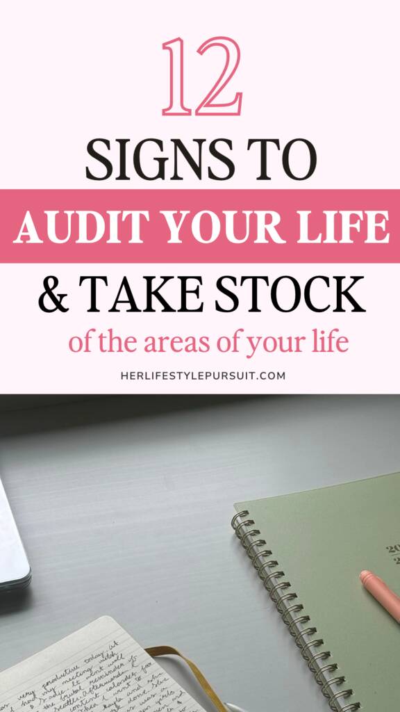 Pink life audit pin with a green spiral notebook, pink pen, and handwritten journal on a gray desk.